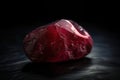 Red beryl is a rare precious natural geological stone on a black background in low key. AI generated Royalty Free Stock Photo