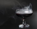 Red beverage cocktail with fume on black background with copy space Royalty Free Stock Photo