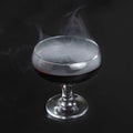 Red beverage cocktail with fume on black background with copy space Royalty Free Stock Photo