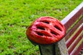 Red bicycle helmet resting on park bench Royalty Free Stock Photo