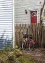 Red Bicycle Leaning Against an Old Fence on a Stone Path