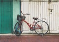 Red bicycle parked in front of white and green wall Royalty Free Stock Photo