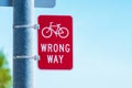 Red bicycle wrong way Sign on street pole