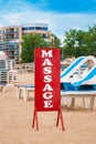 Red big massage sign stands on the beach