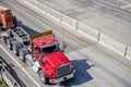 Big rig red semi truck with oversize load sign on the roof transporting oversized equipment on the semi trailer