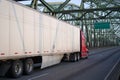 Red big rig semi truck transporting commercial cargo in dry van