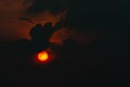 Red big sun in dark clouds. Devil sunset. Horror view of sun in black clouds sky. Summer sunset. Fiery sun in the evening. Nature Royalty Free Stock Photo