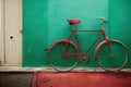 Red bike against a green wall Royalty Free Stock Photo