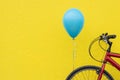 Red bike, blue balloon, bright yellow wall