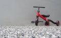 A red bike for children with cement wall behide at home. Mother teaching his son to ride a bike Royalty Free Stock Photo