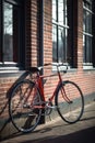 Red bike leaning against building wall in city street, created using generative ai technology Royalty Free Stock Photo