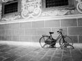 Red bike leaning against a wall in black and white Royalty Free Stock Photo