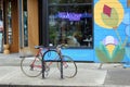 a red bike locked up outside a blue and green building