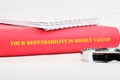A red binder is positioned with a motivational message emphasizing the importance of dependability. A silver pen rests