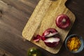 Red bisect onion, tomato, turmeric on wooden table. Close-up fro