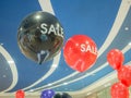 Red and black balloons with white inscription sale under the white-blue ceiling of the mall Royalty Free Stock Photo