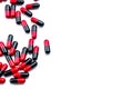 Red-black capsule pills spread on white background. Antibiotic drug use with reasonable. Pharmaceutical industry. Pharmacy