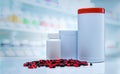 Red-black capsules pills spread on counter in drugstore. Blank label plastic drug bottle on blurred background of vitamins and Royalty Free Stock Photo