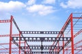 Red and black Castellated Beam metal of Industrial Building Structure in Construction Site against blue sky background