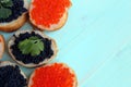 Red and black caviar of fish lies on wheat bread