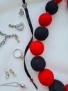 Red and black felt balls. Woolen beads and silver jewelry. Royalty Free Stock Photo