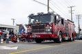 A red and black fire truck driving in the Christmas parade