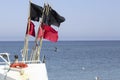 Red and black flags on the boat on the sea in Denmark