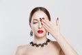 Red and black gradient nails and lips combination set. Beautiful young woman covering her eye with her hand, nude makeup false Royalty Free Stock Photo