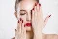 Red and black gradient nails and lips combination set. Beautiful young woman covering her eye with her hand, nude makeup false Royalty Free Stock Photo