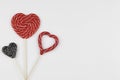 Red and black hearts as lollipop candy. Valentines day minimalist background. love symbol, space for text concept Royalty Free Stock Photo