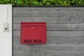 red and black mailbox hangs on the wooden fence door in front of the house, wall green tree background, object, decor, modern,