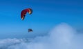 Red and black paramotor in the blue sky view.