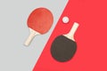 Red and black ping pong paddles with a white ball