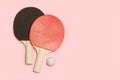 Red and black ping pong paddles with a white ball
