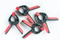 Red and black plastic carpenters pinch tools flat lay above white background