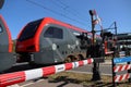 Red and black R-net train at a railroad crossing in Waddinxveen between Alphen aan den Rijn and Gouda