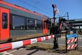 Red and black R-net train at a railroad crossing in Waddinxveen between Alphen aan den Rijn and Gouda