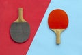 Red and black rackets for table tennis on blue and red background. Ping pong sports equipment in minimal style. Flat lay, top view Royalty Free Stock Photo