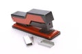 Red and black stapler with extra staples on squared paper Royalty Free Stock Photo