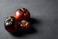 Red-black tomatoes of the bovine heart variety on a black background