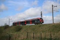 A red black train type Flirt of NS Albellio on the track in Gouda heading Alphen aan den Rijn