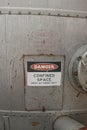a red, black and white Danger, Confined Space warning sign on the metal entrance door of a silo Royalty Free Stock Photo