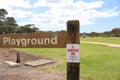 A red, black and white No Dogs Allowed in Playground Area or on