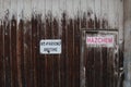 A red, black and white No Parking Any Time and Hazchem signs on old wooden door of abandoned industrial building Royalty Free Stock Photo