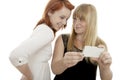 Red and blond haired girls show something on phone Royalty Free Stock Photo