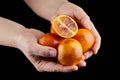 Red or blood orange fruits in hands on black background Royalty Free Stock Photo