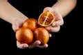 Person holging handful of half and whole red or blood oranges on black background Royalty Free Stock Photo