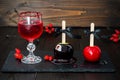 Red bloody vampire cocktail and black poison and red caramel apples. Traditional dessert recipe for Halloween party. Royalty Free Stock Photo