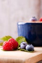 Red and blue berries on chopping board Royalty Free Stock Photo