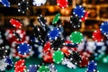 Red, Blue, Black and Green Clay Poker Chips cascading in front of a background of stacked poker chips Royalty Free Stock Photo